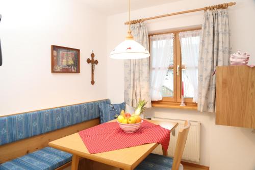 a dining room table with a bowl of fruit on it at Almroeserl in Mittenwald