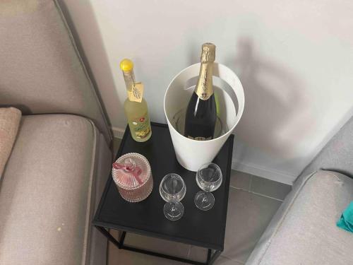 een tafel met twee flessen wijn en glazen erop bij Appartamento confortevole in Deinze