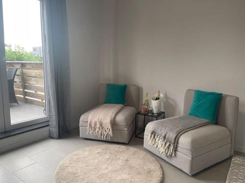 een woonkamer met een stoel en een poef bij Appartamento confortevole in Deinze