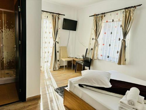 een slaapkamer met een bed en een badkamer met een douche bij Elitegasthaus Moieciu A in Moieciu de Jos