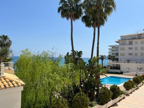 een resort met een zwembad en palmbomen bij Zee zicht apartement Altea 2 pers in Caserío Capnegret