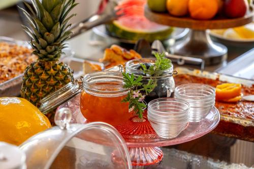 a tray of food with fruit and a jar of honey at Stephanos Hotel Apartments in Polis Chrysochous