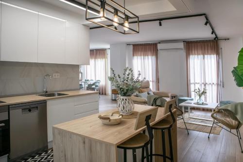 eine Küche und ein Wohnzimmer mit einem Tisch und Stühlen in der Unterkunft Ramos Gardens in Baena