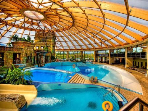 a large swimming pool in a building with a ceiling at AquaSuite Budapest in Budapest