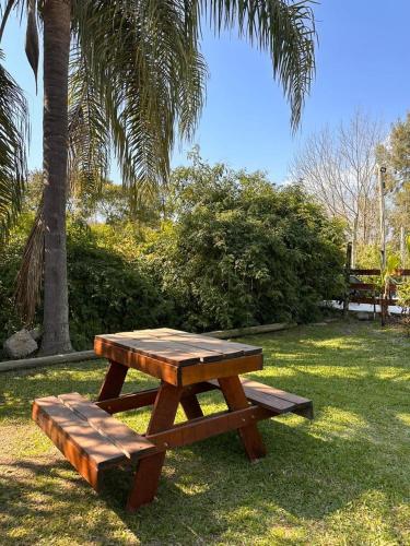 a wooden picnic table and bench in a park at Cabañas Altos de Artalaz in Colón