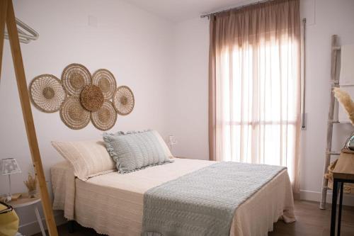 1 dormitorio con cama y ventana grande en Ramos Gardens, en Baena