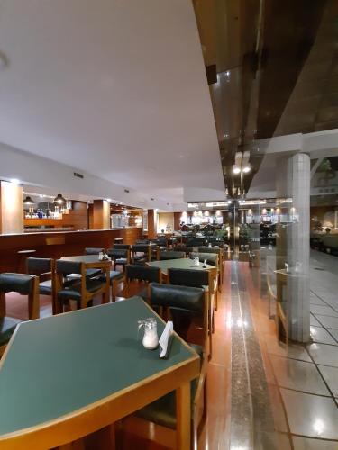 une rangée de tables et de chaises dans un restaurant dans l'établissement Hotel Perugia, à Necochea