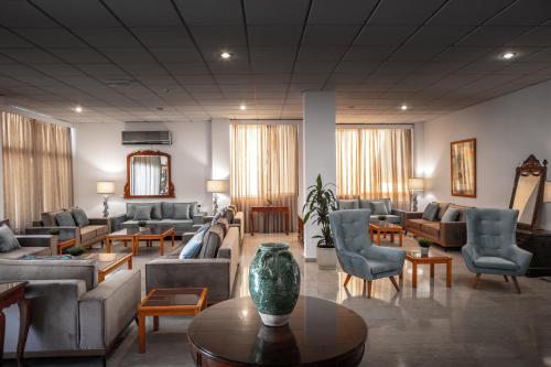 a living room with couches and chairs and a table at Stephanos Hotel Apartments in Polis Chrysochous