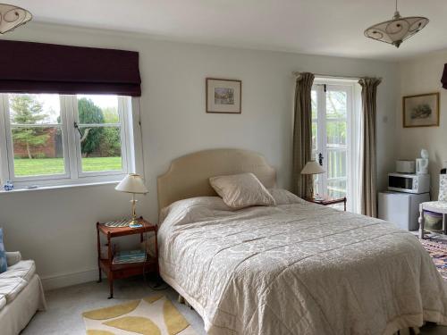 a bedroom with a bed and two windows at The Gardens in Daventry