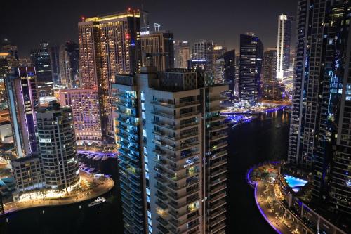 a view of a city at night with lights at Urban Heaven, Luxury Hostel - JBR - Walk To Beach, Metro Station in Dubai