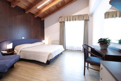 a bedroom with a bed and a desk and a couch at Etoile De Neige in Pila