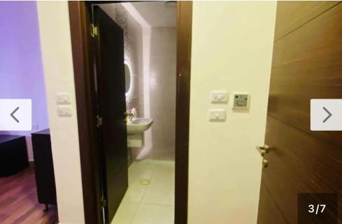 een badkamer met een toilet, een wastafel en een deur bij AMT in Amman