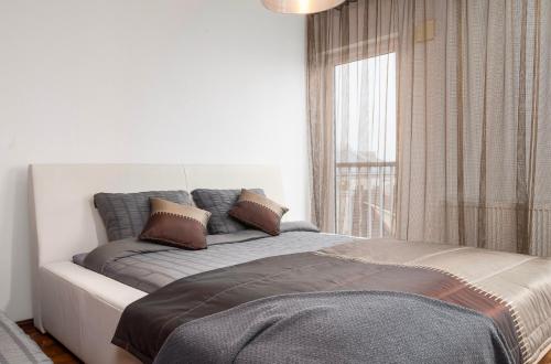 a bed with pillows on it in a room with a window at Mugav suurepärase vaatega korter in Viljandi
