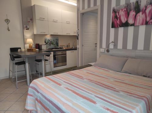 a bedroom with a bed and a desk and a kitchen at Como Petite Maison in Como