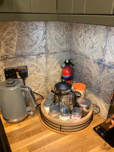 a tray with a tea kettle and cups on a counter at Holmlea Cottage in Moffat
