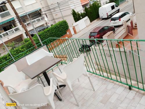 a balcony with a table and chairs and a car at Hotel Sant Jordi in Segur de Calafell