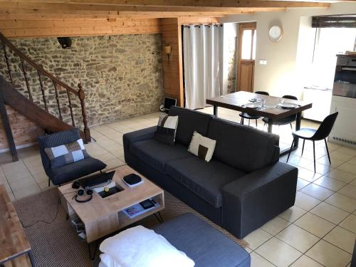 a living room with a couch and a table at Charmante maison en bord de Rance in Plouër-sur-Rance