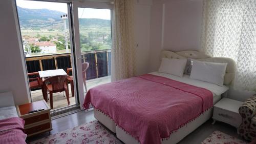 a bedroom with a bed and a large window at Salda Karanfil Pansiyon in Yeşilova