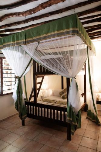 a bed with a canopy in a room at Amani Paradise - Luxury Villas in Diani Beach