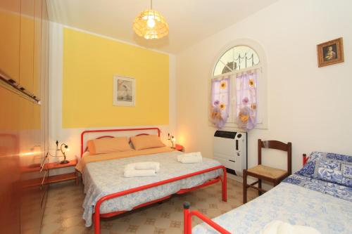 1 dormitorio con 2 camas, silla y ventana en Appennini Villas, en Lido di Pomposa