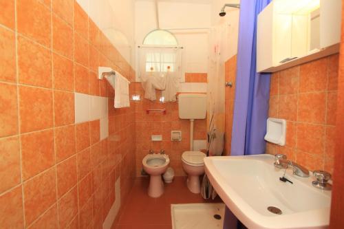 a bathroom with a toilet and a sink at Appennini Villas in Lido di Pomposa
