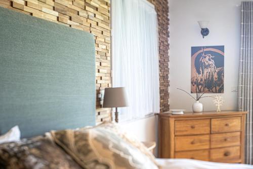 a bedroom with a bed and a dresser and a window at Chez PhiL in La Pomarède