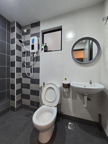 een badkamer met een toilet, een wastafel en een spiegel bij Manhattan Condominium - Jalan Pasir Puteh - Ipoh in Kampong Pinji