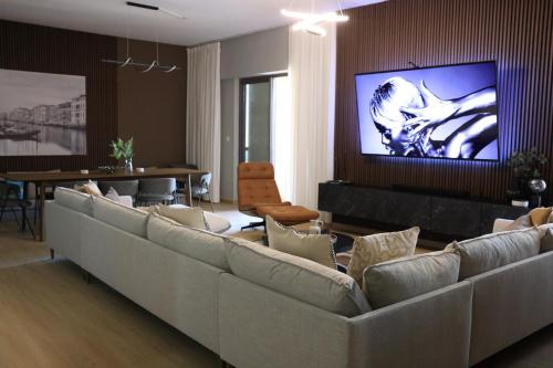 Urban Heaven, Luxury Hostel - JBR - Walk To Beach, Metro Station في دبي: غرفة معيشة مع أرائك وتلفزيون على الحائط