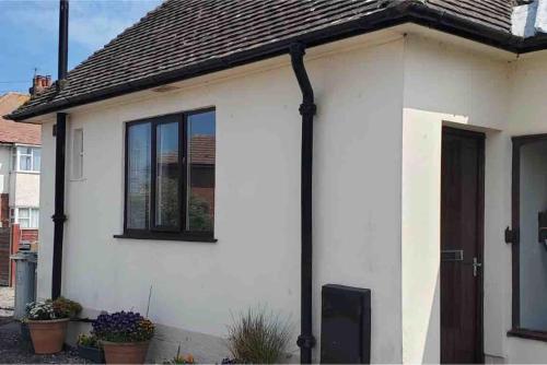 a white house with a door and windows at Tiny one bedroom house in Mablethorpe