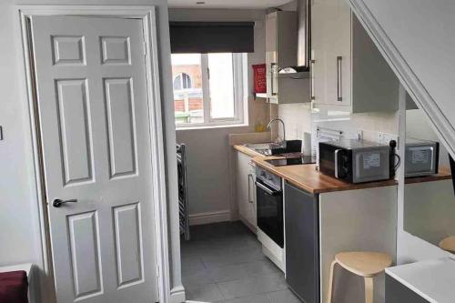 a small kitchen with a door leading into a room at Tiny one bedroom house in Mablethorpe