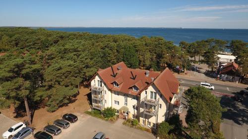 eine Luftansicht eines großen Hauses mit einem Parkplatz in der Unterkunft Hotel Garni Meeresblick in Glowe