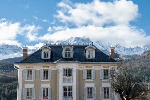 a large house with mountains in the background at Petite Anita - Centre ville - Parking privé in Barcelonnette