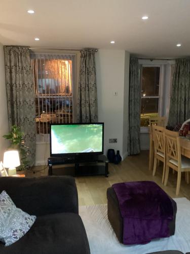 a living room with a tv and a couch at Promenade Sea View Apartment in Ballycastle