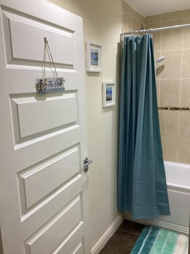 a bathroom with a door and a shower at Promenade Sea View Apartment in Ballycastle
