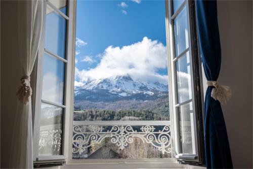 a window with a view of a snow covered mountain at Petite Anita - Centre ville - Parking privé in Barcelonnette