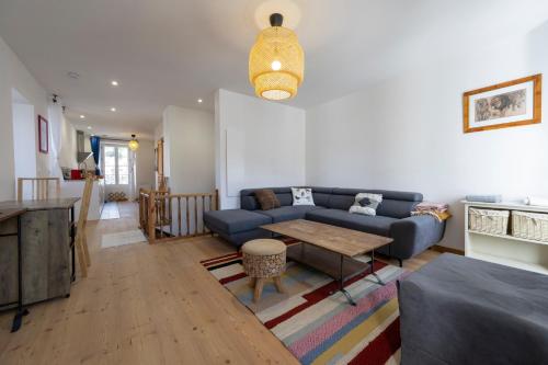 a living room with a blue couch and a table at Petite Anita - Centre ville - Parking privé in Barcelonnette