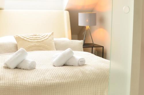 een slaapkamer met een wit bed en handdoeken bij MILPAU Bottrop 3 - Modernes und zentrales Premium-Apartment mit Queensize-Bett - Netflix, Nespresso und Smart-TV in Bottrop