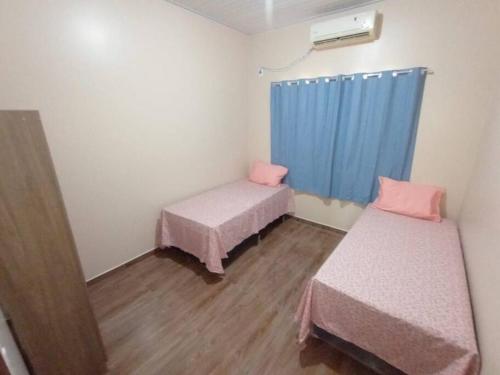 a room with two beds and a blue curtain at Apartamento Mobiliado aconchegante - Wi-Fi in Boa Vista
