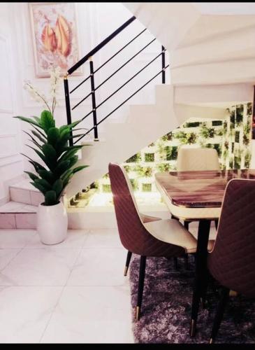 a dining room with a table and chairs and a staircase at Luxury House In Lekki Lagos in Ikota