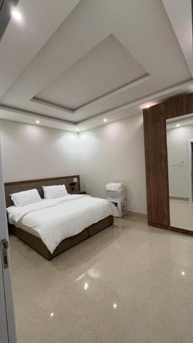 een slaapkamer met een groot wit bed in een kamer bij شقق السيف الفندقية in Riyad
