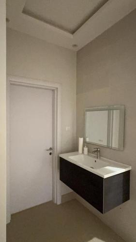 een badkamer met een wastafel en een spiegel bij شقق السيف الفندقية in Riyad