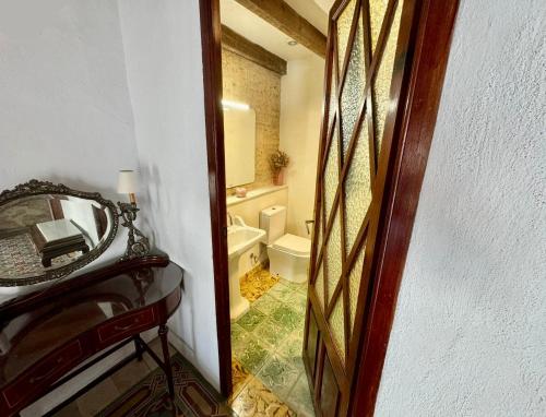 ein Badezimmer mit einem WC, einem Waschbecken und einem Spiegel in der Unterkunft Oliva Courtyard Guesthouse in Oliva