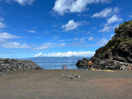 a group of people on a beach near the water at Adega Baía Azul - The essence of Pico in São Roque do Pico