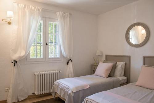 une chambre blanche avec deux lits et une fenêtre dans l'établissement Opio Villa with private pool, à Opio