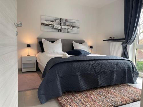 a bedroom with a bed with a black comforter at Appartamento ideal in Tielt