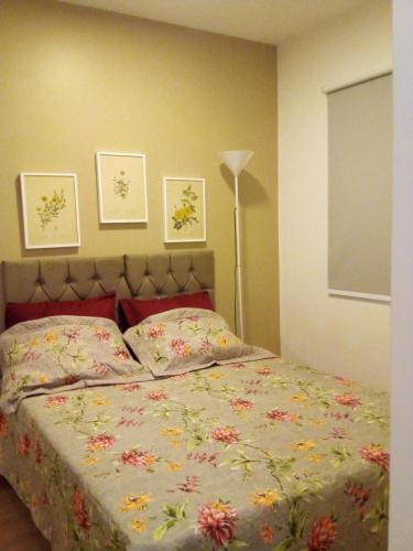 a bedroom with a bed with a floral comforter at Serra Verde Imperial ! APT com Suíte, Quitandinha - vista para o Verde !! in Petrópolis