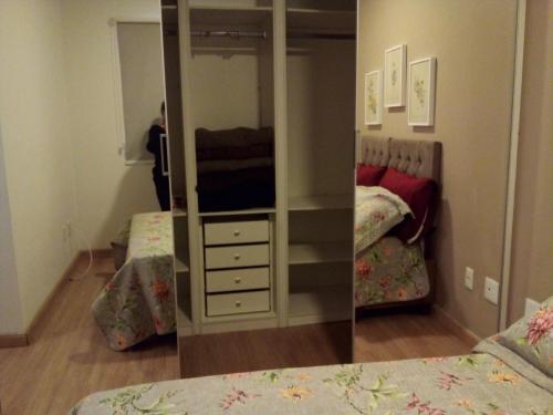a bedroom with a mirror and a bed and a dresser at Serra Verde Imperial ! APT com Suíte, Quitandinha - vista para o Verde !! in Petrópolis