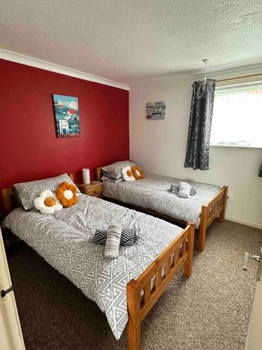 two beds in a room with red walls at 129 Sunset Chalet in Hemsby