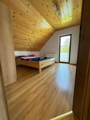 Duży pokój z łóżkiem i drewnianym sufitem w obiekcie Domek na Skarpie w Wiśle