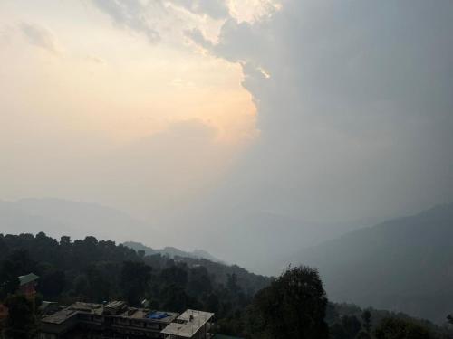 a view of a foggy valley with a building and trees at Hangkhim Homestay in Ravangla